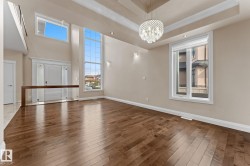 Spacious interior featuring high ceilings with a tiered tray design and a prominent crystal chandelier - 
