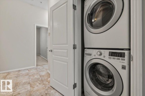 Dedicated laundry closet with a stacked washer and dryer unit - 228 10531 117 Street, Edmonton, AB - Indoor Photo Showing Laundry Room