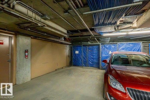 Underground parking space with concrete flooring and exposed utility lines - 228 10531 117 Street, Edmonton, AB - Indoor Photo Showing Garage