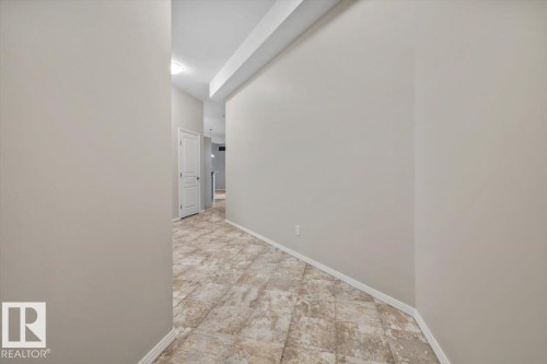 Interior hallway featuring neutral wall tones and patterned tile flooring - 228 10531 117 Street, Edmonton, AB - Indoor Photo Showing Other Room