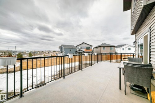 The property features a spacious deck with a black metal railing, offering views of the surrounding neighborhood - 4509 170A Avenue, Edmonton, AB - Outdoor With Exterior