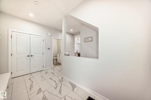 The entryway features light-colored walls and white tile flooring with gray veining - 4509 170A Avenue, Edmonton, AB - Indoor Photo Showing Other Room