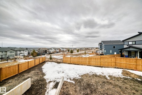 The property includes a spacious backyard with a wooden fence and features views of the surrounding neighborhood - 4509 170A Avenue, Edmonton, AB - Outdoor