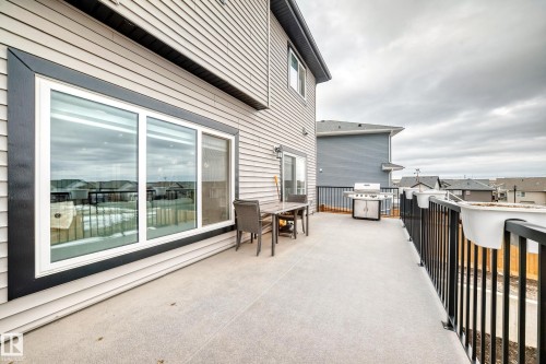 The property features an outdoor patio with a dark railing and a sliding glass door - 4509 170A Avenue, Edmonton, AB - Outdoor With Exterior