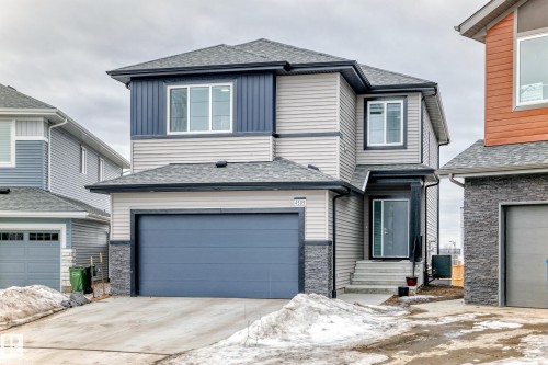 The property features a two-story design with light-colored siding, dark blue accents, and stone detailing on the facade - 4509 170A Avenue, Edmonton, AB - Outdoor