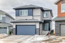 The property features a two-story design with light-colored siding, dark blue accents, and stone detailing on the facade - 4509 170A Avenue, Edmonton, AB  - Outdoor 