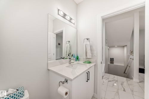 This bathroom features a contemporary vanity with a white countertop and a rectangular sink - 4509 170A Avenue, Edmonton, AB - Indoor Photo Showing Bathroom