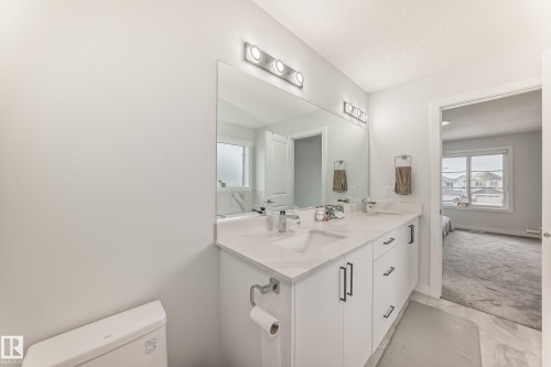 Bathroom featuring a dual sink vanity with a white countertop and a large mirror - 4509 170A Avenue, Edmonton, AB - Indoor Photo Showing Bathroom