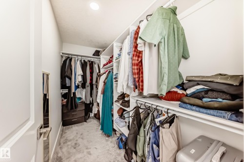 Walk-in closet featuring carpeted flooring, recessed lighting, and shelving and hanging rods for storage - 4509 170A Avenue, Edmonton, AB - Indoor With Storage