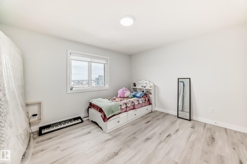 Bedroom featuring light-colored flooring, a window with a view, and a ceiling light fixture - 4509 170A Avenue, Edmonton, AB - Indoor Photo Showing Bedroom
