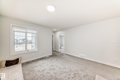 This room features light grey carpeting, white walls, and a window providing natural light - 4509 170A Avenue, Edmonton, AB - Indoor Photo Showing Other Room