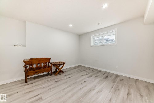 This bright room features light grey wood-style flooring and recessed lighting - 4509 170A Avenue, Edmonton, AB - Indoor Photo Showing Other Room