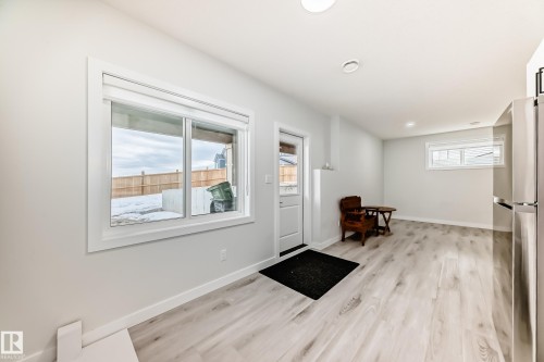 This versatile space features light-toned flooring, white walls, and bright windows allowing for natural light - 4509 170A Avenue, Edmonton, AB - Indoor Photo Showing Other Room
