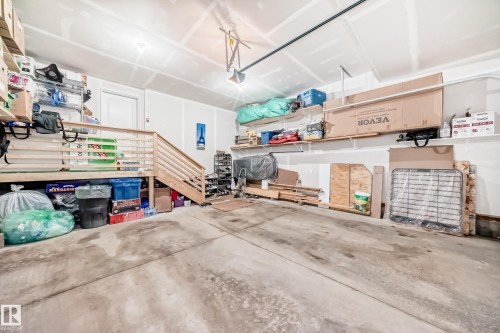 The property includes a spacious garage with a concrete floor, built-in shelving, and a wooden staircase - 4509 170A Avenue, Edmonton, AB - Indoor Photo Showing Garage
