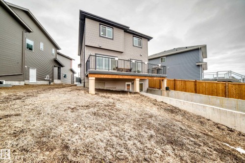 The property features a rear deck with black railings, accessible via a sliding glass door - 4509 170A Avenue, Edmonton, AB - Outdoor With Deck Patio Veranda With Exterior