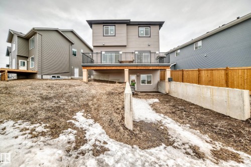 The property features a rear deck with black railings, a walk-out basement, and a wooden fence along the property line - 4509 170A Avenue, Edmonton, AB - Outdoor With Exterior