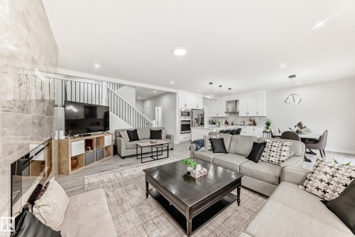 Open concept living area featuring light-colored flooring, recessed lighting, and a modern kitchen with stainless steel appliances and white cabinetry - 4509 170A Avenue, Edmonton, AB - Indoor Photo Showing Living Room