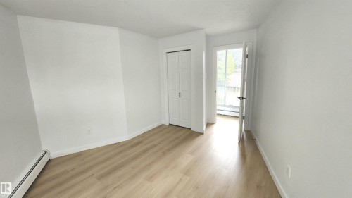 Bright interior space featuring light wood-finish flooring, white walls, and a bi-fold closet door - 9535 147 Avenue, Edmonton, AB - Indoor Photo Showing Other Room