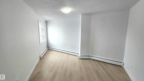 Room featuring neutral white walls, light wood-finish flooring, and white trim - 9535 147 Avenue, Edmonton, AB - Indoor Photo Showing Other Room