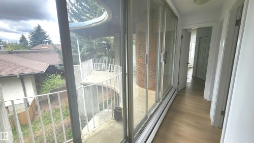 Corridor featuring wood-finish flooring, white baseboards, and a series of white paneled doors - 9535 147 Avenue, Edmonton, AB - Indoor Photo Showing Other Room