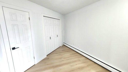Interior room featuring light wood-finish flooring and white walls - 9535 147 Avenue, Edmonton, AB - Indoor Photo Showing Other Room