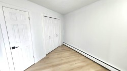 Interior room featuring light wood-finish flooring and white walls - 