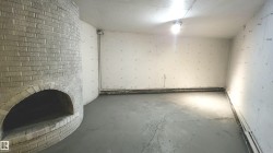 Curved brick fireplace feature, concrete flooring, and exposed utility piping - 
