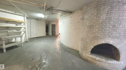 Spacious interior featuring concrete flooring and a curved, white-painted brick alcove - 