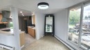Modern kitchen featuring light wood cabinetry, white countertops, and a dark tile backsplash - 9535 147 Avenue, Edmonton, AB  - Indoor 