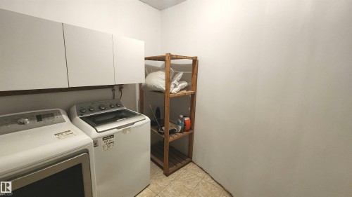 White wall-mounted cabinetry provides storage - 9535 147 Avenue, Edmonton, AB - Indoor Photo Showing Laundry Room