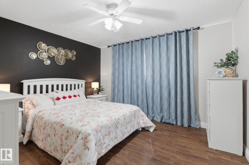 Rich wood-finish flooring complements a contrasting accent wall - 15232 120 Nw, Edmonton, AB 