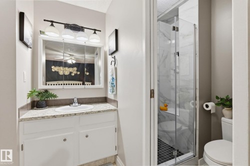 Bathroom featuring a vanity with a light-colored countertop and white cabinetry - 15232 120 Nw, Edmonton, AB 