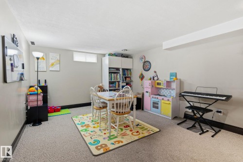 Finished basement space featuring light beige walls and textured carpeting - 15232 120 Nw, Edmonton, AB 