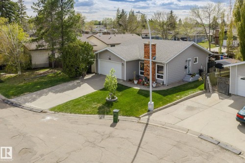 Single-story residence featuring grey siding and a prominent brick chimney - 15232 120 Nw, Edmonton, AB 