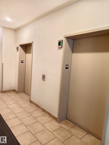 The property features two elevators and a tiled floor in the common area - 209 7511 171 Street Nw, Edmonton, AB - Indoor Photo Showing Other Room