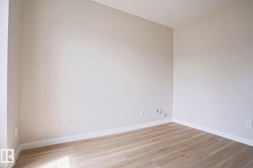 Neutral-toned walls complement wood-finish flooring - 82 Meadowview Point(E), Sherwood Park, AB - Indoor Photo Showing Other Room