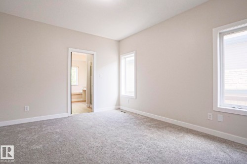 Spacious interior room with light grey wall paint and grey carpet flooring - 82 Meadowview Point(E), Sherwood Park, AB - Indoor Photo Showing Other Room