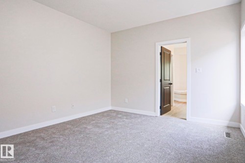 Spacious room featuring light gray carpeting, white baseboards, and neutral wall tones - 82 Meadowview Point(E), Sherwood Park, AB - Indoor Photo Showing Other Room