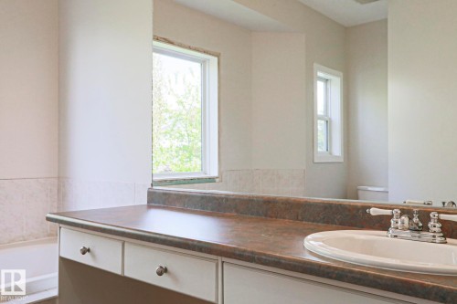 Bathroom vanity featuring an integrated sink, polished chrome faucet, and ample counter space - 82 Meadowview Point(E), Sherwood Park, AB - Indoor Photo Showing Bathroom