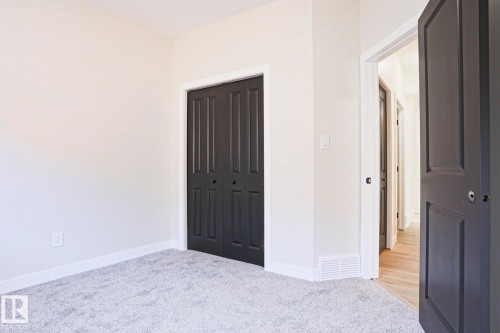 Neutral-toned room featuring light gray carpeting, white baseboards, and bright white wall paint - 82 Meadowview Point(E), Sherwood Park, AB - Indoor Photo Showing Other Room