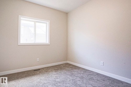 Carpeted room featuring a white-framed window, light-toned walls, and white baseboards - 82 Meadowview Point(E), Sherwood Park, AB - Indoor Photo Showing Other Room