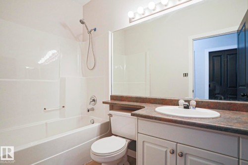 Bathroom featuring a white vanity with cabinet storage, a wide mirror, and a coordinating vanity light fixture - 82 Meadowview Point(E), Sherwood Park, AB - Indoor Photo Showing Bathroom