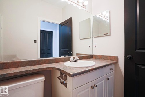 Bathroom vanity with a white basin sink, polished chrome faucet, and integrated brown countertop - 82 Meadowview Point(E), Sherwood Park, AB - Indoor Photo Showing Bathroom