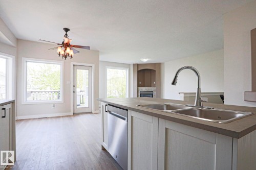 Kitchen island with a dual stainless steel sink and a polished chrome pull-down faucet - 82 Meadowview Point(E), Sherwood Park, AB - Indoor Photo Showing Kitchen With Double Sink