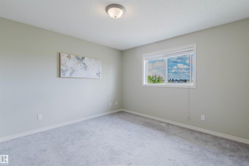 Neutral-toned room featuring a single window with white trim, light grey carpeting, and white baseboards - 3534 Mclean Crescent, Edmonton, AB - Indoor Photo Showing Other Room
