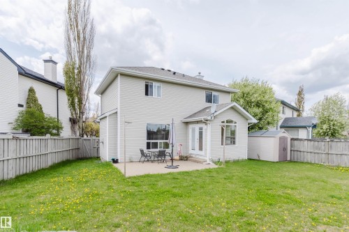 Expansive green lawn featuring a concrete patio, a bay window, and a storage shed - 3534 Mclean Crescent, Edmonton, AB - Outdoor