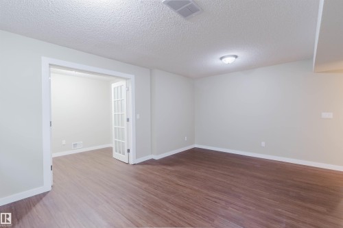 Expansive room featuring wood-finish flooring and a neutral color palette - 3534 Mclean Crescent, Edmonton, AB - Indoor Photo Showing Other Room