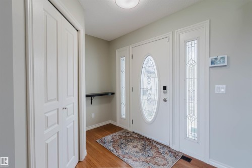 Entryway featuring a white door with an oval leaded glass insert, flanked by coordinating vertical leaded glass side lights - 3534 Mclean Crescent, Edmonton, AB - Indoor Photo Showing Other Room