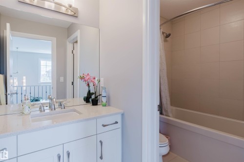 Contemporary bathroom featuring a white vanity with a light speckled countertop and brushed nickel hardware - 3571 Keswick Boulevard, Edmonton, AB - Indoor Photo Showing Bathroom