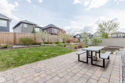 Expansive backyard featuring a paver patio, manicured lawn, and raised garden beds - 3571 Keswick Boulevard, Edmonton, AB - Outdoor